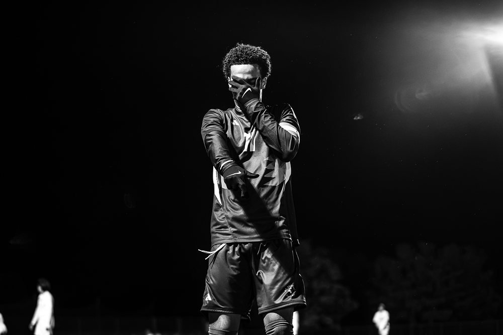 Black and white of a soccer player with his hand over his face